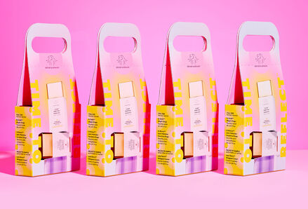 Packaged Time to Reflect Kits with handles side by side on a pink background.
