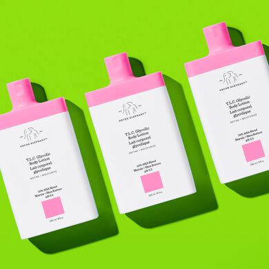 photograph of multiple T.L.C. Glycolic Body Lotion bottles on a green background