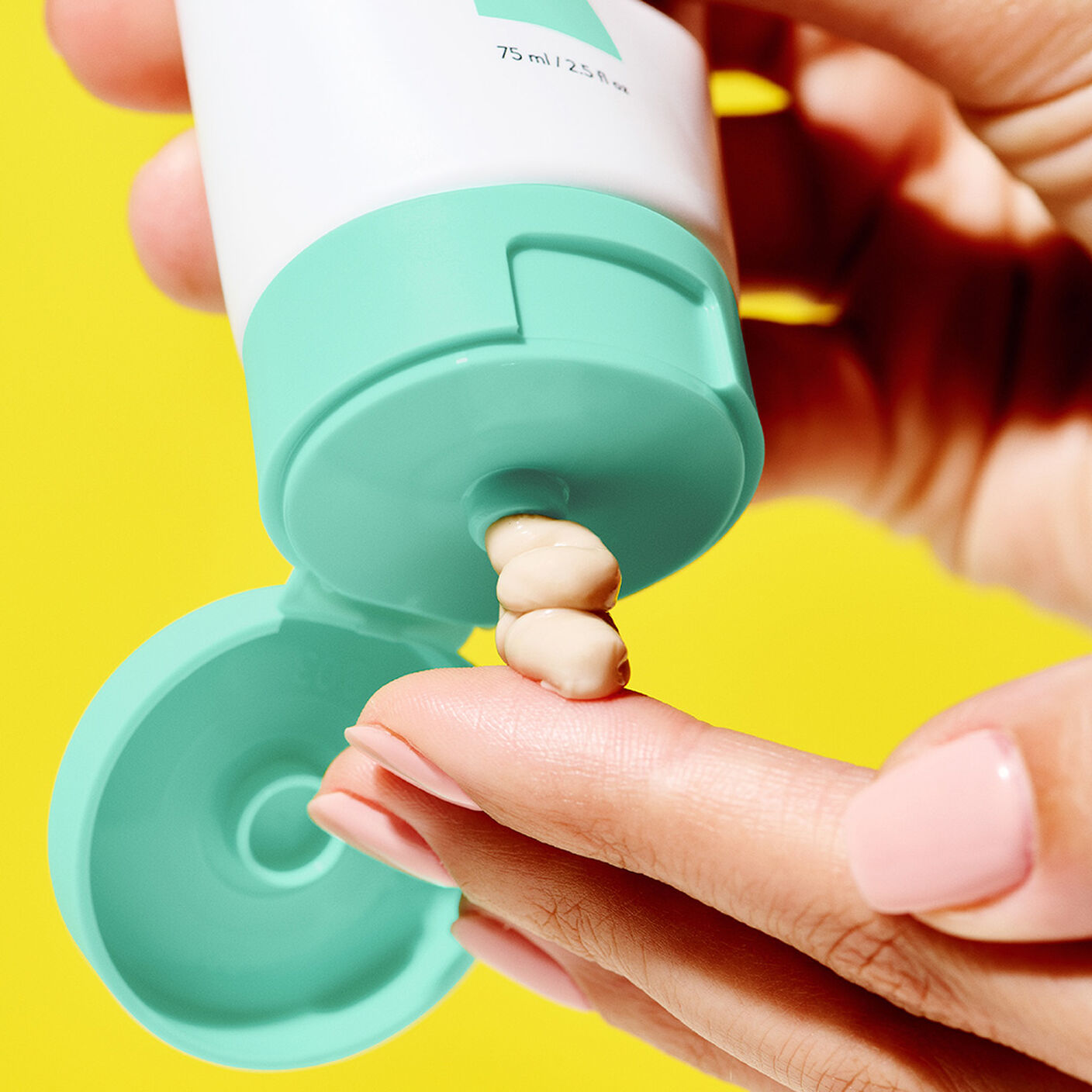 Close up shot of model squeezeing out product onto fingers. 