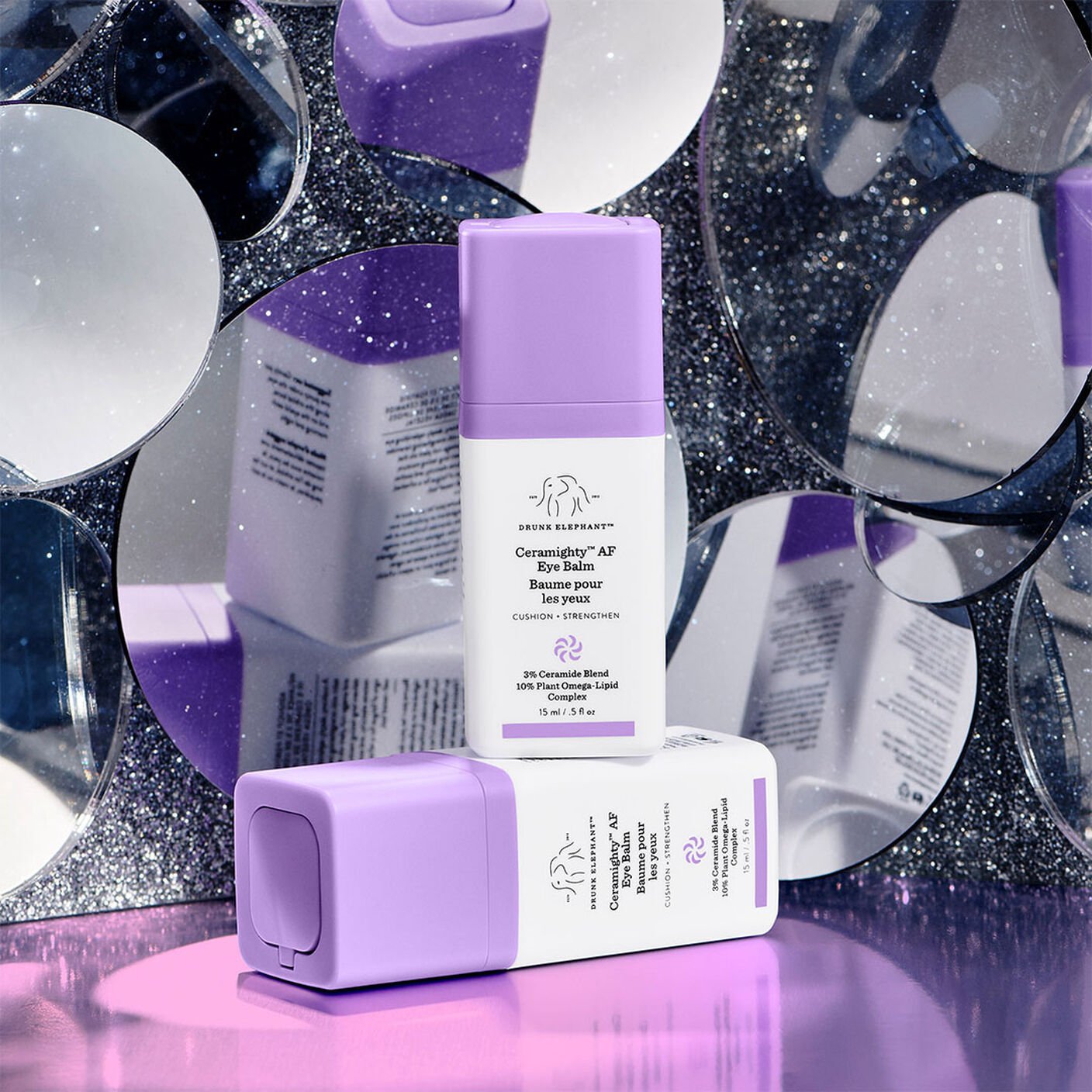 Creamighty AF Eye Balm in front of a number of circular mirrors and on a purple table. 