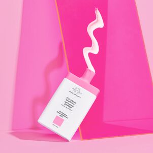 photograph of T.L.C. Glycolic Body Lotion with lotion coming out of the bottle against a pink background