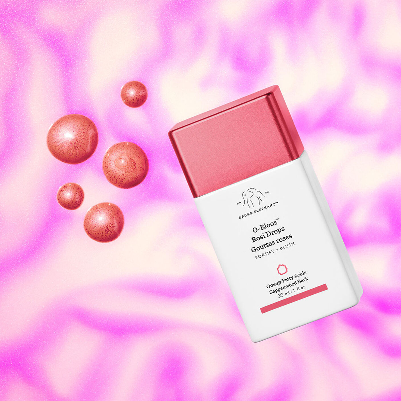 O-Bloos bottle floating in front of a pink and white background with drops of serum next to it. 