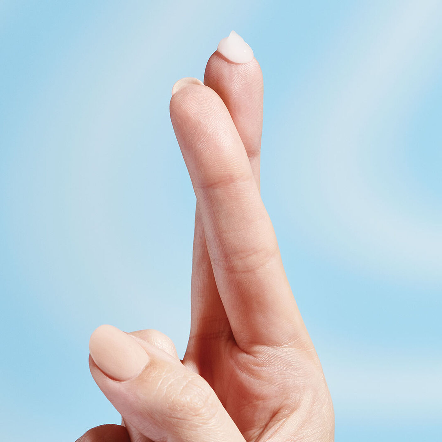 A drop of B-Hydra serum sitting on the top of the finger tip. 