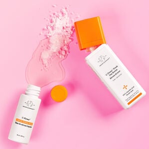 Image of C-Firma Fresh bottles opened with liquid and powder poured out onto a pink background