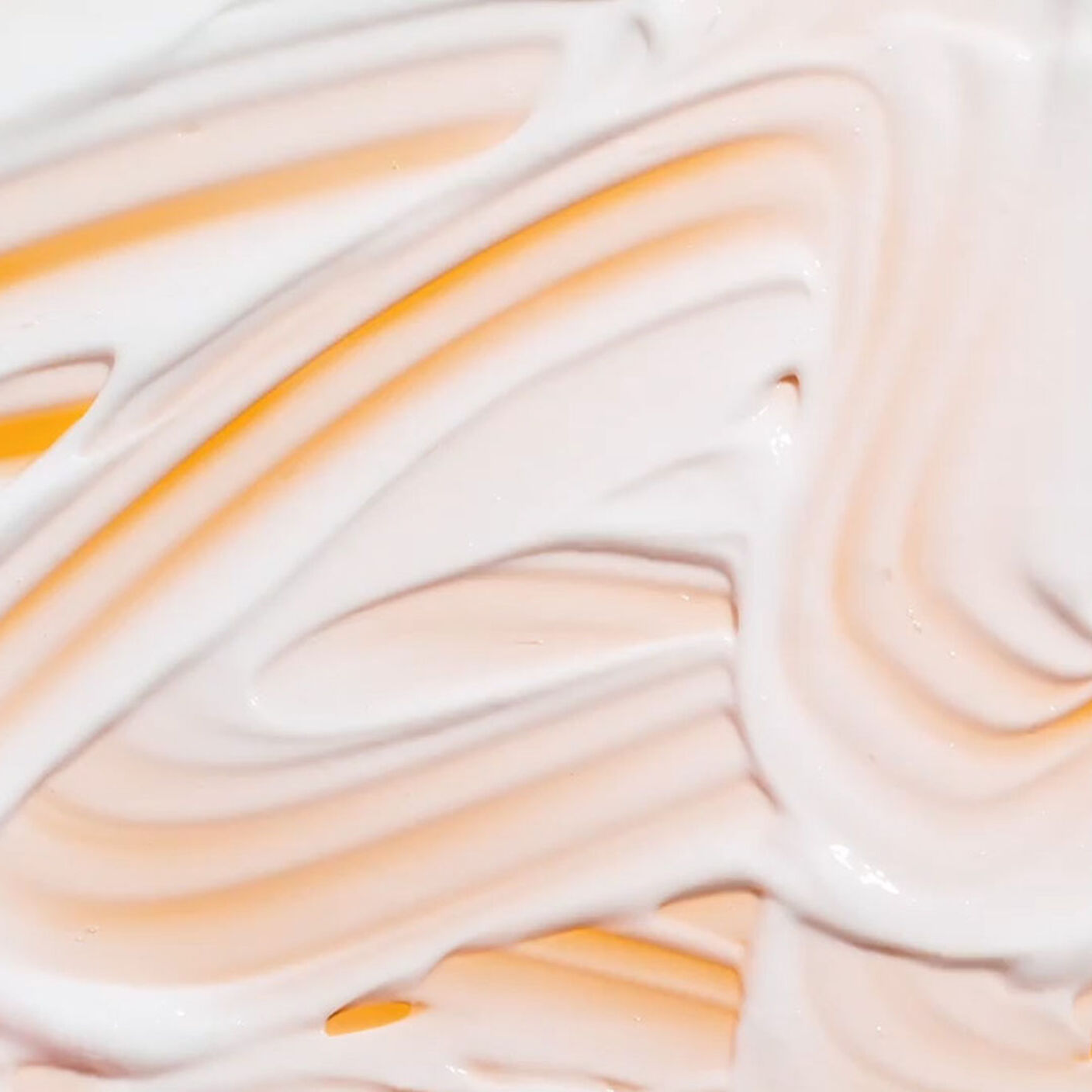 Texture shot of Bouncy Brightfacial mask smared on an orange background. 