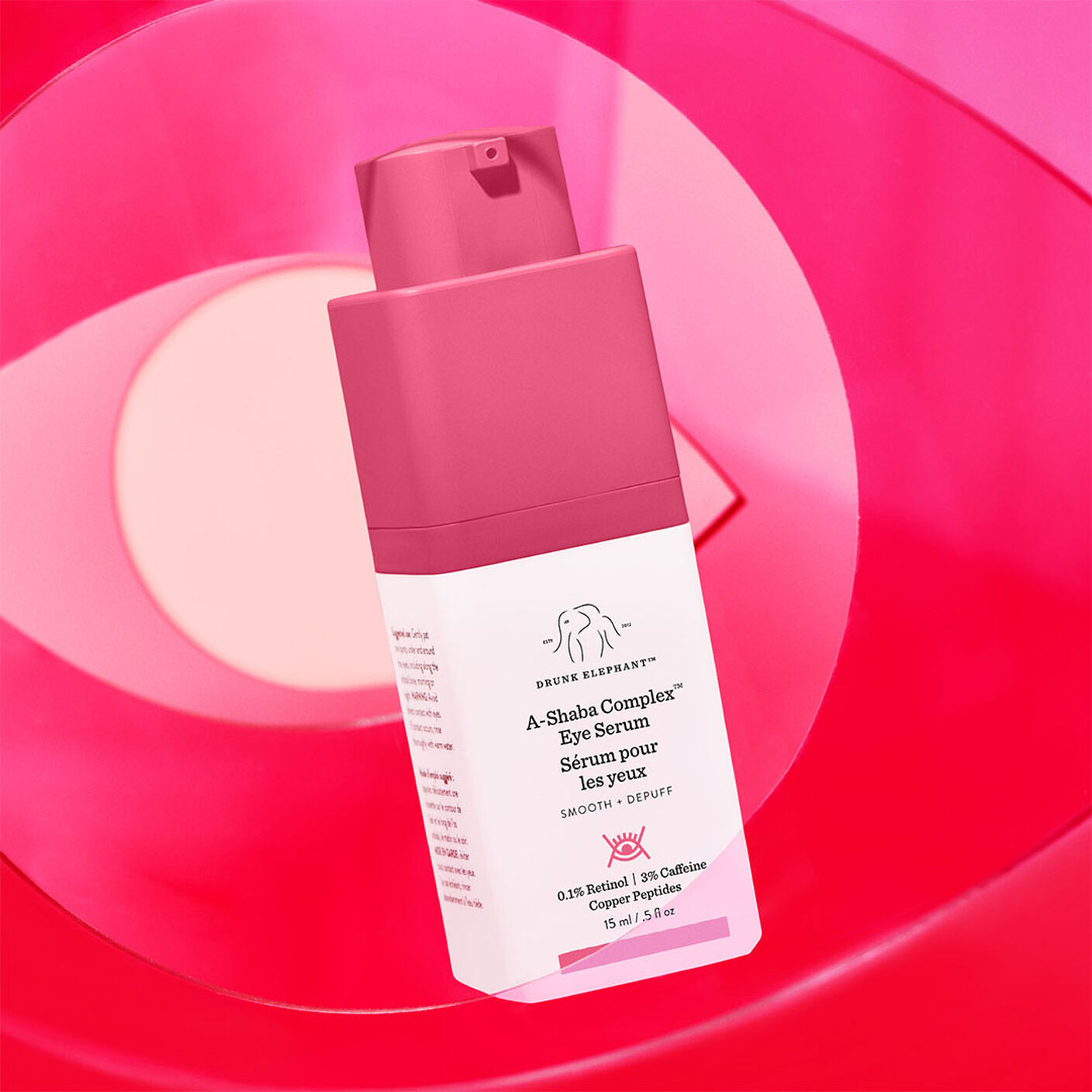 A-Shaba Complex Eye Serum in front of an eye shaped pink acrylic top. 