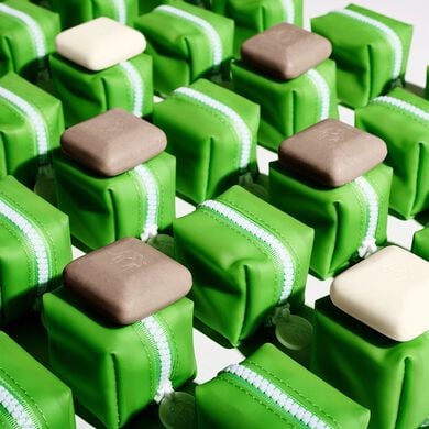 photo of several baby bar duo zipper cases aligned in a grid on a white surface some with baby pekee and baby juju bars on top