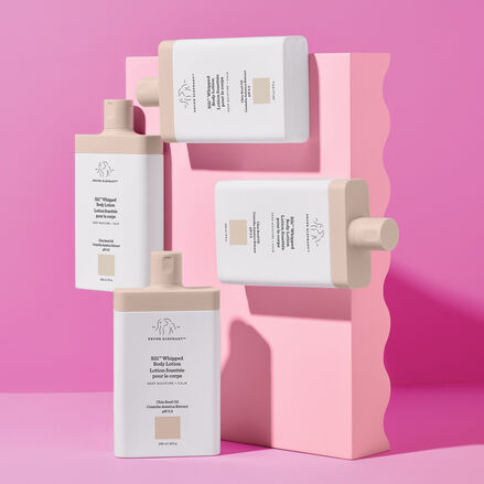 Four Sili Whipped bottles pinned up against a pink block