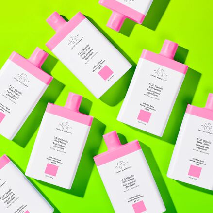 photo of multiple T.L.C. Glycolic Body Lotion bottles on green background