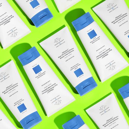 Multiple bottles of Silkamino Mega-Moisturizing Masker laid flat on a neon green background