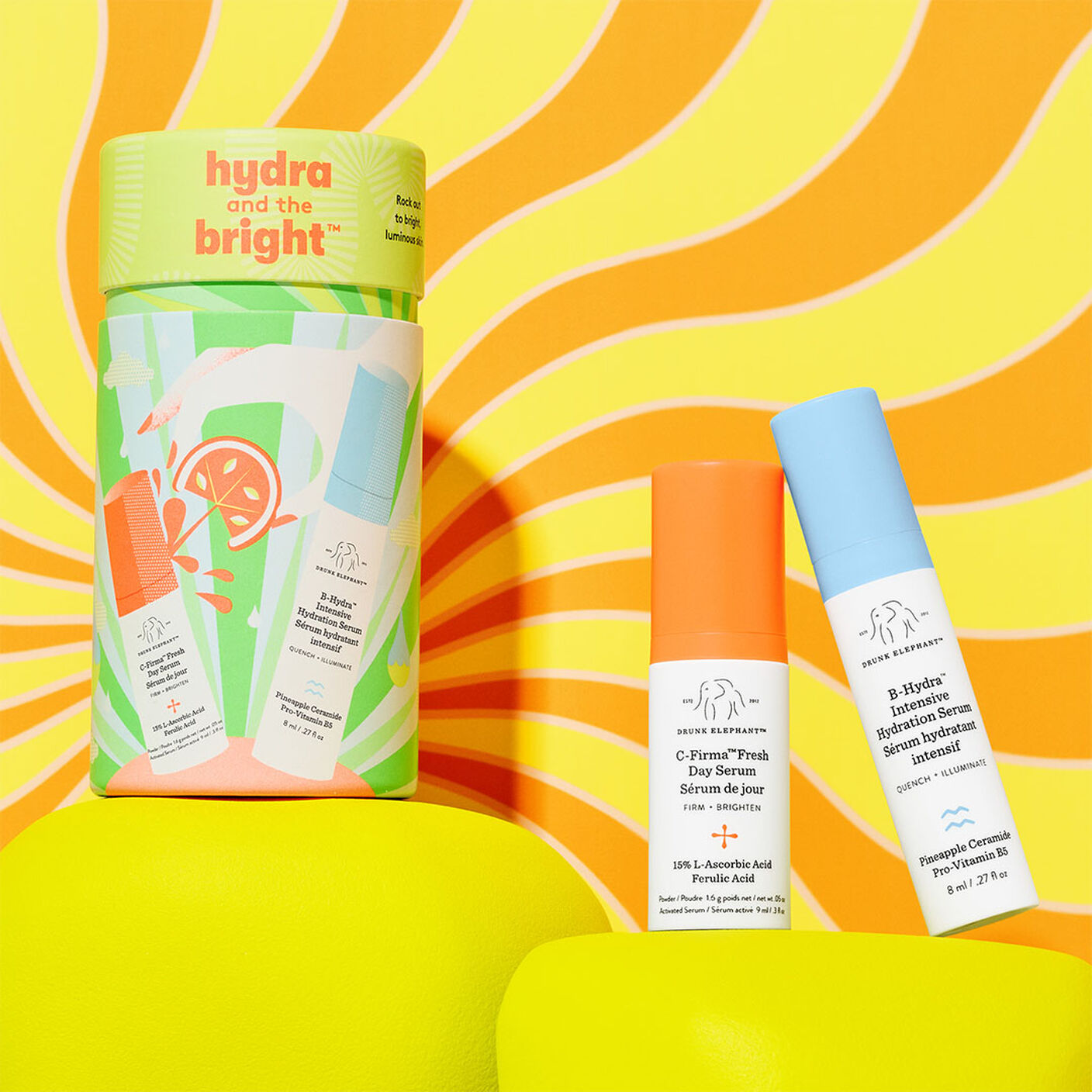Hydra and the Bright clylindrical package along with C-Firma Fresh (9ml) and B-Hydra (8ml) on a yellow prop on an orange and yellow background. 