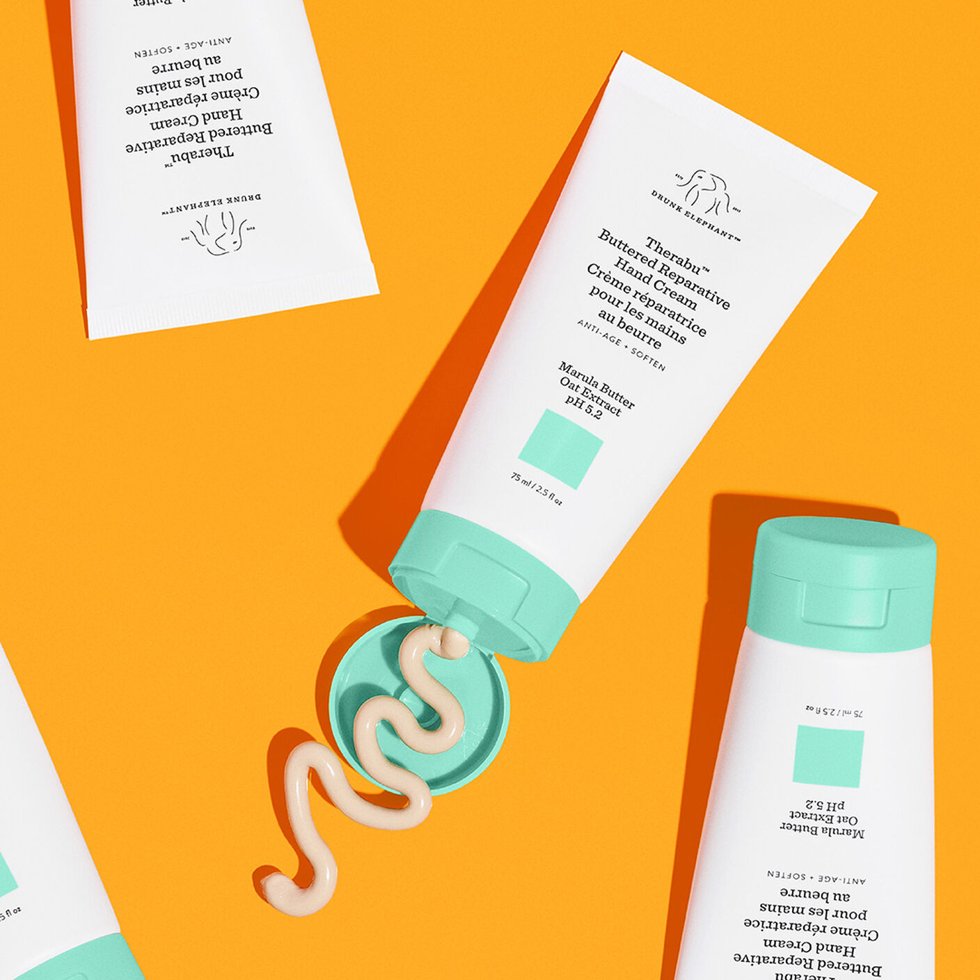 Multiple bottles of Therabu hand cream with one bottle open with product coming out. 