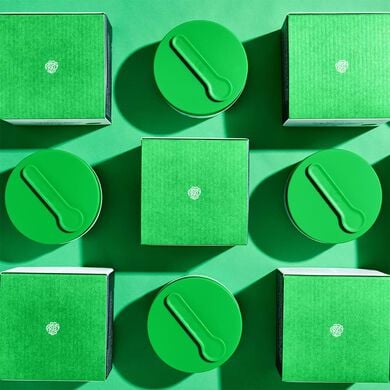 photo of Slaai inner and outer packaging arrayed in an alternating grid pattern against a green background