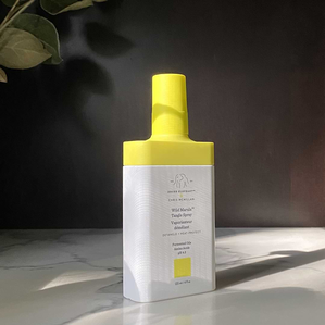 photo of a tangle spray bottle in a sunbeam on a marbled surface