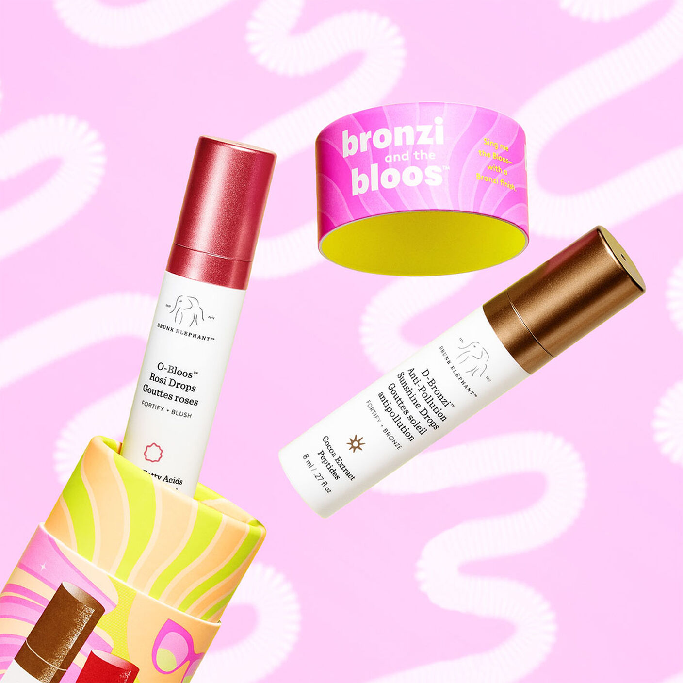O-Bloos and D-bronzi coming ou of packaging on a pink and white background. 