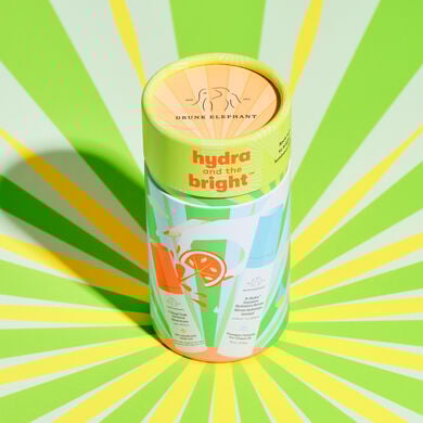 Cylinder packaging with 8ml B-Hydra and 9ml C-Firma fresh on a sun ray patetrened floor with yellow and green.
