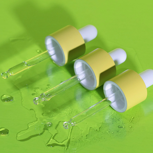 photo of three Marula Oil dropper caps aligned on a bright green surface with product spilled out onto the table