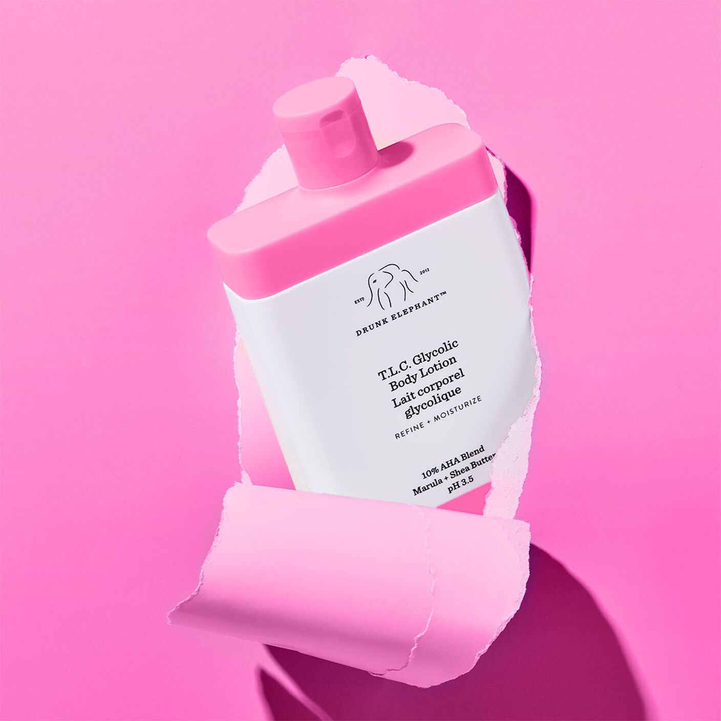 T.L.C Glycolic Body Lotion poking through a ripped hot pink poster