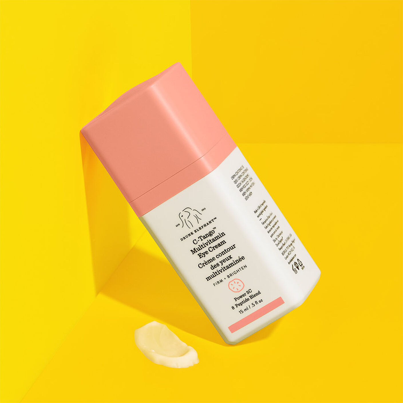 C-Tango Multivitamin Eye Cream  leaning on a yellow background with a small cream smear. 