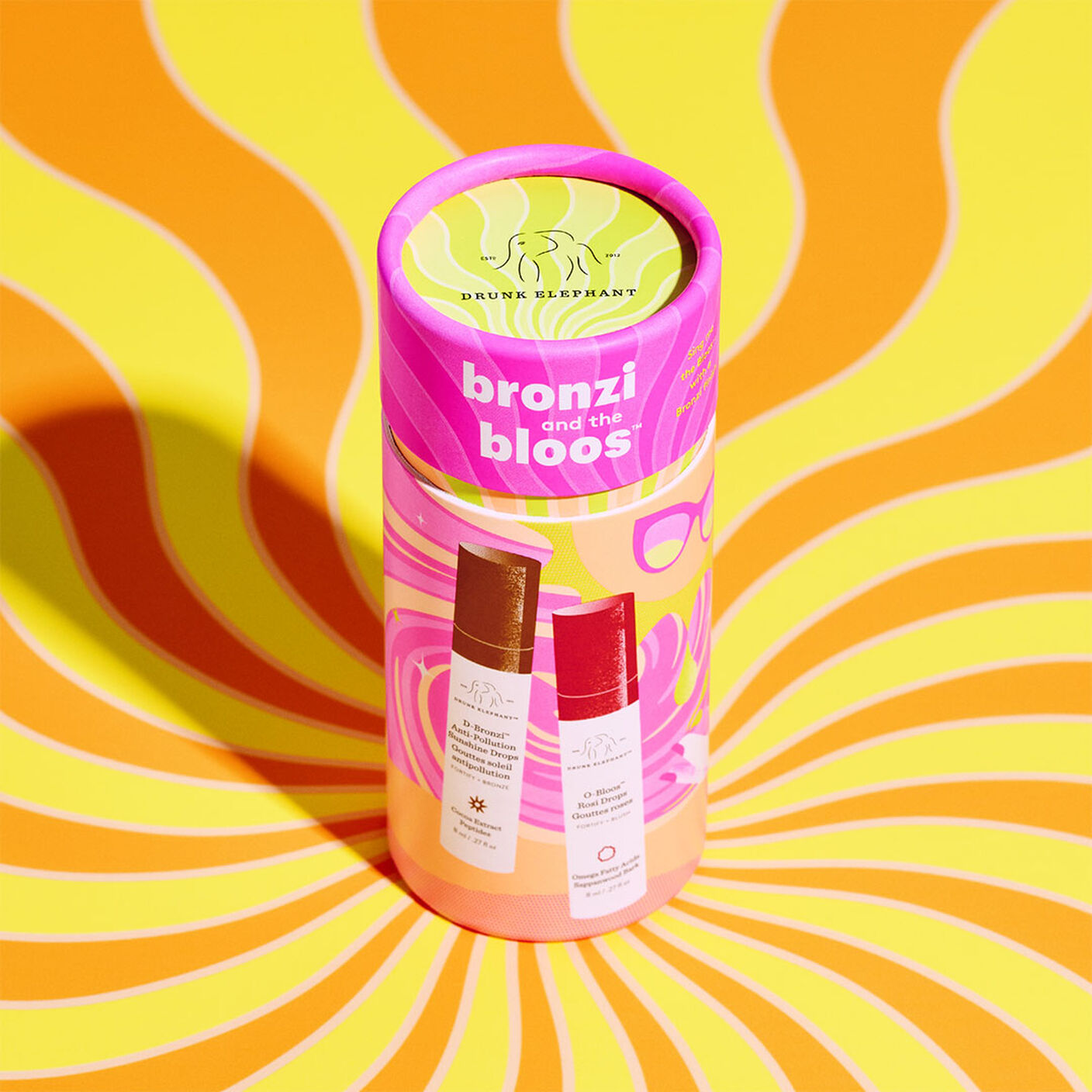 Cylindrical packaging on a swirly orange and yellow table. 