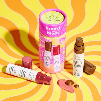 8ml of D-Bronzi next to pink and orange cylinder packaging and and 8ml of O-Bloos on its side with texture shot of both in front on packaging in front of yellow and orange swirly background.